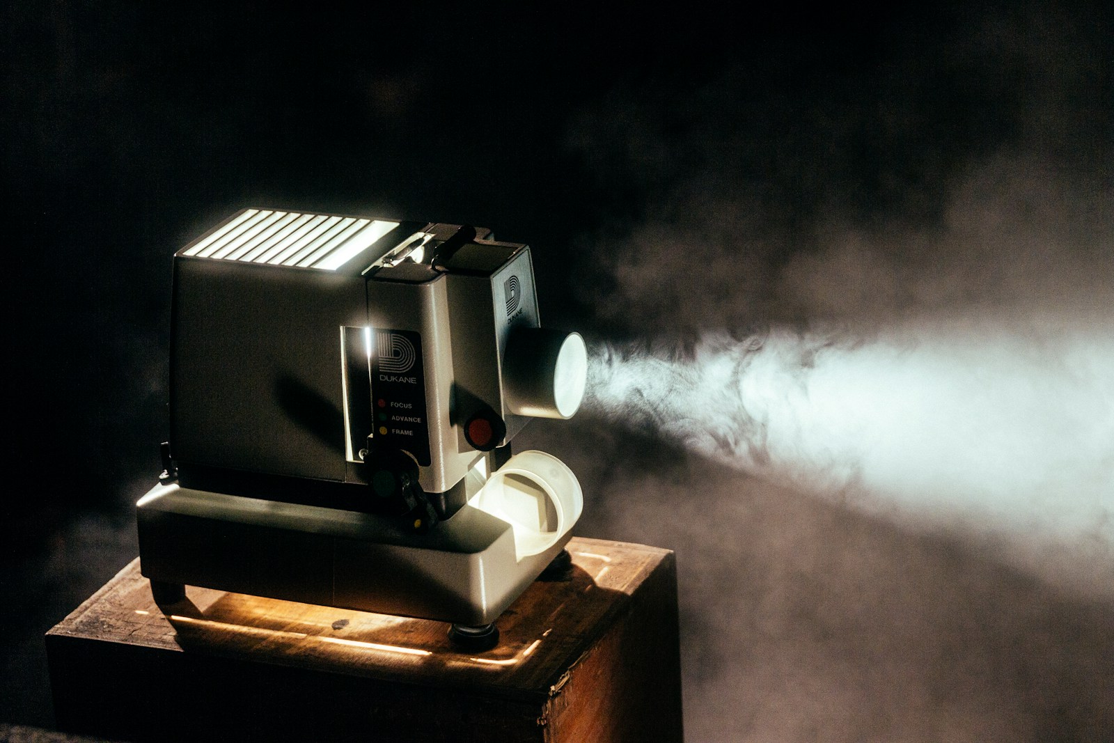 A vintage film projector casting a beam of light through a dark room